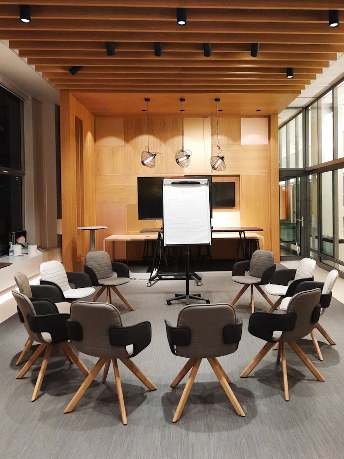 Mastering the First Impression: Your intriguing post title goes here A modern conference room featuring circular seating and a flip chart, ideal for meetings and presentations.