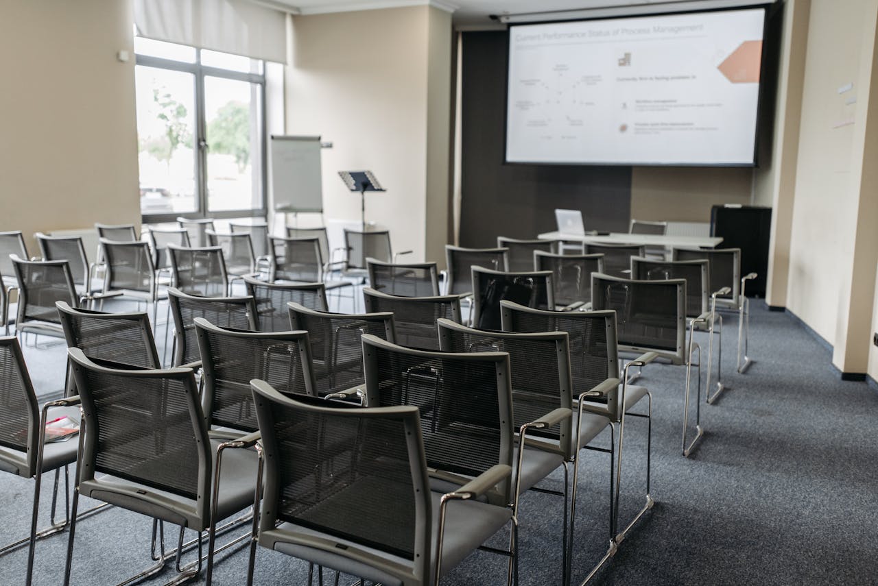 The Art of Drawing Readers In: Your attractive post title goes here Spacious empty conference room with arranged chairs, screen, and natural light for professional meetings.